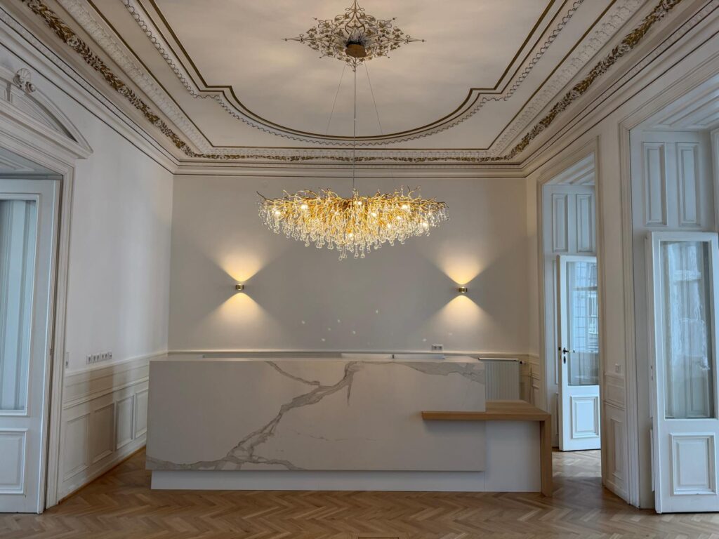 Empfangsbereich der Pichler Rechtsanwalt GmbH am Karlsplatz 3 in Wien mit Stuckdecke, Luster und Marmortresen
